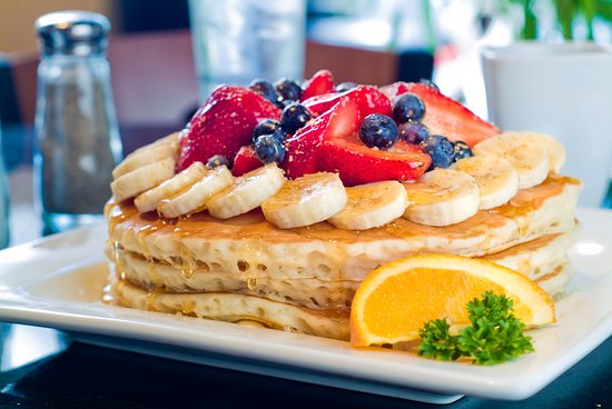 Pancakes topped with fresh berries and banana